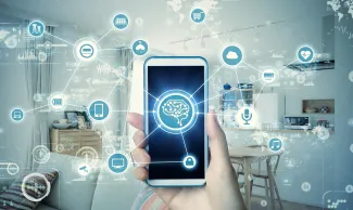 PROMO HIRES Technology Cell Phone Education - metamorworks . iStock-968113166 Hand holding a cell phone in front of a home scene surrounded by icons of various technologies