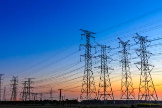 PROMO HIRES Energy Power Lines Electric Grid - zhaojiankang - iStock-802436842 Group of high voltage power line towers at sunset